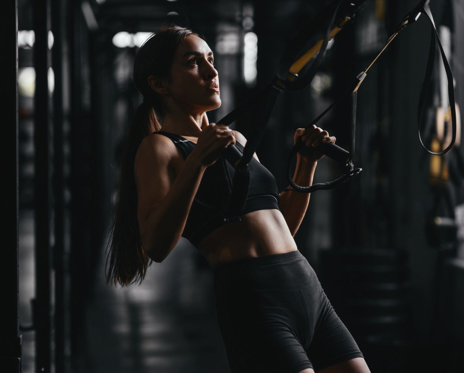 Umind Ubody Fit young woman at a gym style on dark gray background